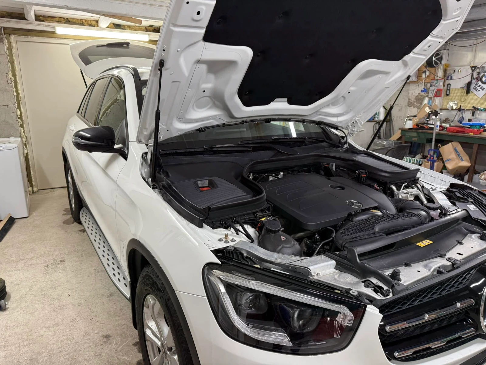 Mercedes GLC med öppen motorhuv i verkstaden